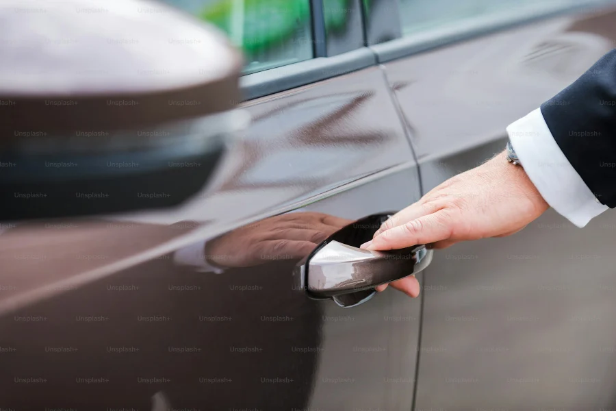 Fahrer im Anzug öffnet die hintere Fahrzeugtür